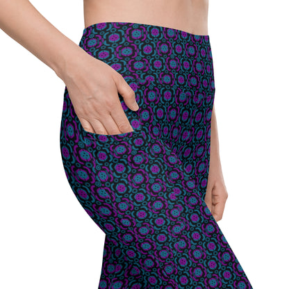 Close-up side view of the Purple Playmaker Pickleball Leggings, showing the intricate pickleball-themed pattern in purple and blue. The person's hand is placed inside the functional side pocket.